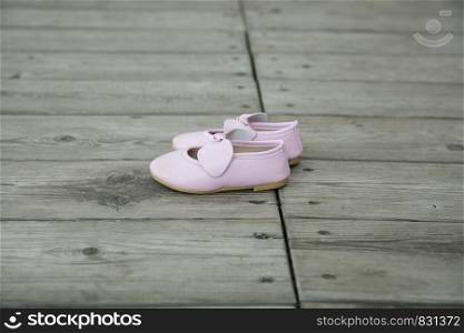 City Cesis, Latvian Republic. Pink baby booties stand on a wooden floor. July 14 2019. Travel photo.