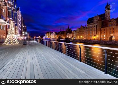 City embankment and facades of medieval houses in the old city at sunset. Gdansk. Poland.. Gdansk. City embankment in night illumination.