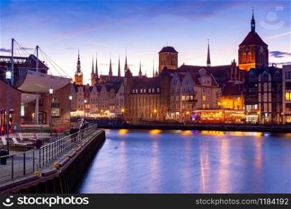 City embankment and facades of medieval houses in the old city at sunset. Gdansk. Poland.. Gdansk. City embankment in night illumination.