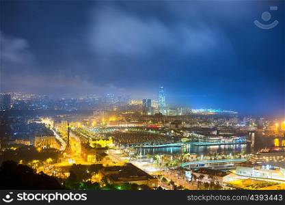 City of Barcelona at night. View on port and cityscape with blue dark sky