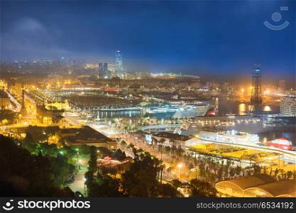 City of Barcelona at night. View on port and cityscape with blue dark sky. City of Barcelona at night