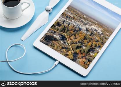city of Fort Collins in northern Colorado in fall scenery, reviewing an aerial image on a digital tablet