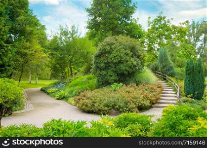 City park with beautiful trees, shrubs and a decorative staircase.