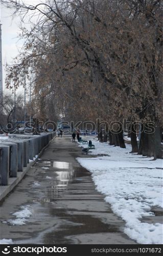 city park with melting snow in center of Yekaterinburg city, Russia