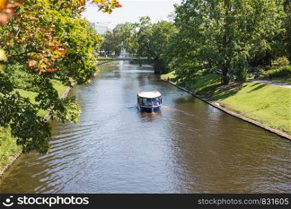 City Riga, Latvian Republic. A tourist boat flies through the canal.2019. 24. July.