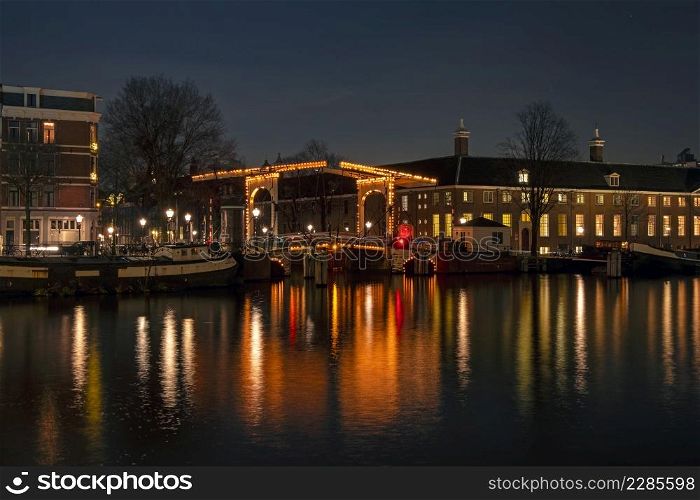 City scenic from Amsterdam at the Amstel in the Netherlands at night