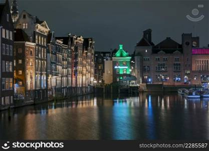 City scenic from Amsterdam at the Damrak in the Netherlands at night