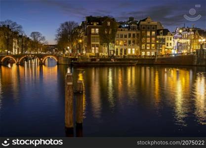 City scenic from Amsterdam at the river Amstel in the Netherlands at sunset
