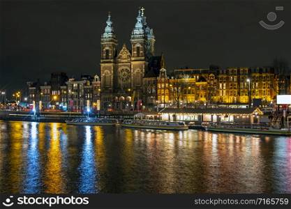 City scenic from Amsterdam in the Netherlands at night with the St. Niklaas church