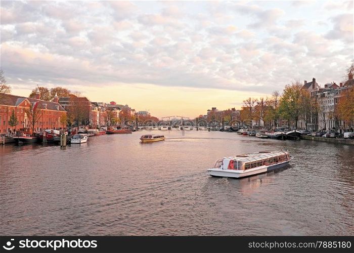 City scenic from Amsterdam in the Netherlands at the river Amstel at twilight