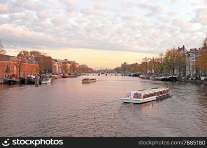 City scenic from Amsterdam in the Netherlands at the river Amstel at twilight