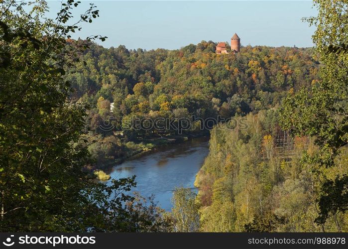 City Sigulda, Latvia Republic. Old castle, build from red bricks. Around trees with yellow leafs. 27. Sep. 2019