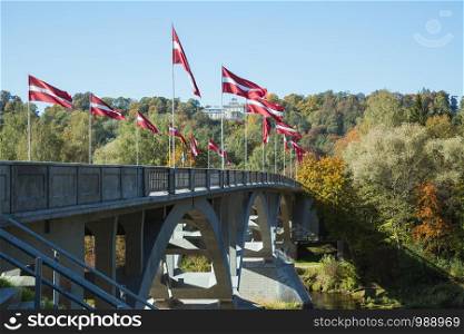 City Sigulda, Latvia Republic. River and bridge with flags in Autumn. 27. Sep. 2019