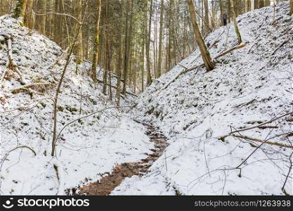 City Sigulda, Latvia. Small river with sand rock and snow in winter.Travel photo.29.02.2020