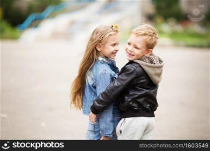 City style. Urban kids. Portrait of two happy children - boy and girl. Brother and sister hugging. School holidays concept. The first children&rsquo;s love