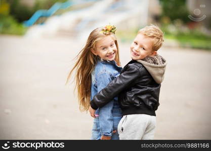 City style. Urban kids. Portrait of two happy children - boy and girl. Brother and sister hugging. School holidays concept. The first children’s love