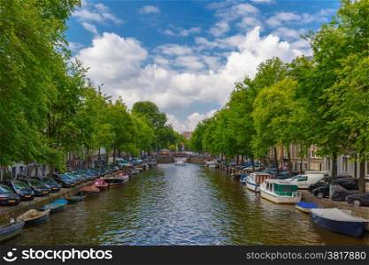 City view of Amsterdam canal and bridge with boats and cars, Holland, Netherlands.