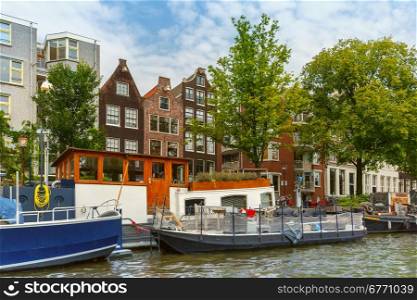 City view of Amsterdam canal and typical houses, boats and bicycles, Holland, Netherlands.