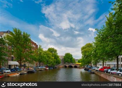 City view of Amsterdam canal, bridge and boats, Holland, Netherlands.