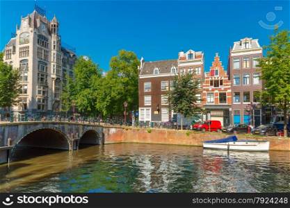 City view of Amsterdam canal, bridge and typical houses, boat and bicycles, Holland, Netherlands.