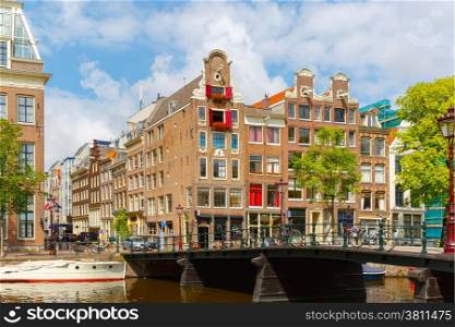 City view of Amsterdam canal, bridge and typical houses, boats and bicycles, Holland, Netherlands.