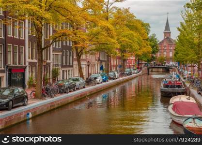 City view of Amsterdam canal, church and typical houses, boats and bicycles, Holland, Netherlands.