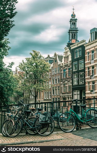 City view of Amsterdam canal, church Westerkerk and typical houses, boats and bicycles, Holland, Netherlands... Toning in cool tones