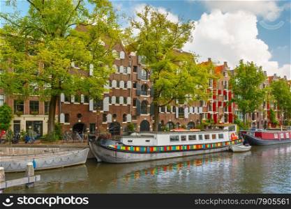 City view of Amsterdam canal with picturesque houseboats and typical houses, Holland, Netherlands.