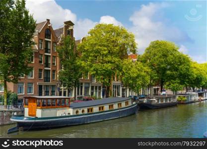 City view of Amsterdam canal with picturesque houseboats and typical houses, Holland, Netherlands.
