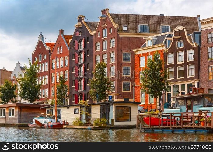 City view of Amsterdam canal with typical houses and houseboats, Holland, Netherlands.