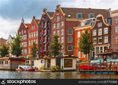 City view of Amsterdam canal with typical houses and houseboats, Holland, Netherlands.