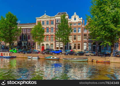 City view of Amsterdam canals and typical houses, boats and bicycles, Holland, Netherlands.