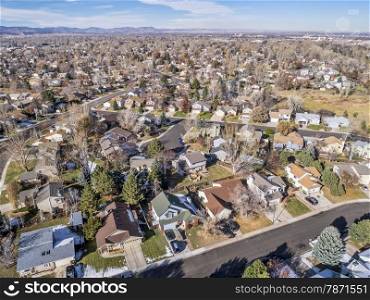 cityscape of a typical residential area along Colorado Front Range - aerial view of Fort Collins from a low flying drone, foothills of Rocky Mountains in background