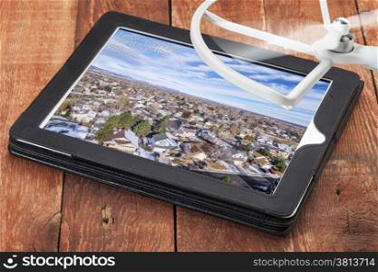 cityscape of Fort Collins, Colorado - reviewing aerial pictures from a low flying drone on a digital tablet with spinning drone rotor in background, screen image created by the photographer