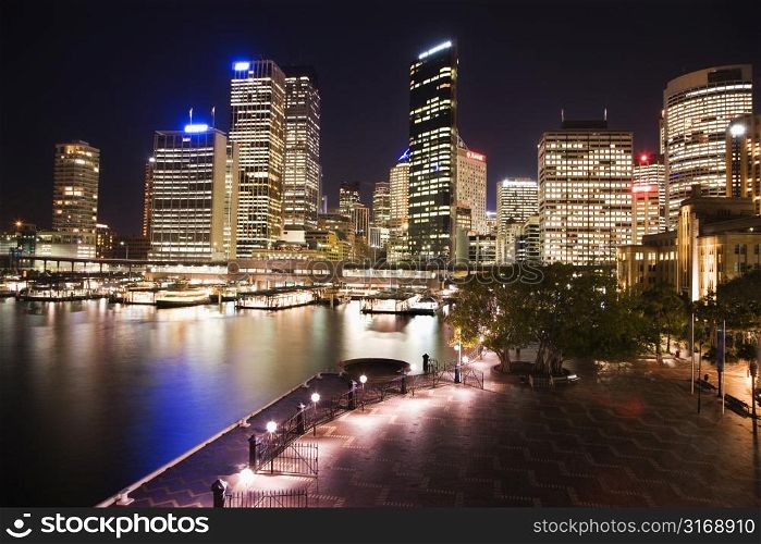 Cityscape of Sydney, Australia with harbor and buildings at night.