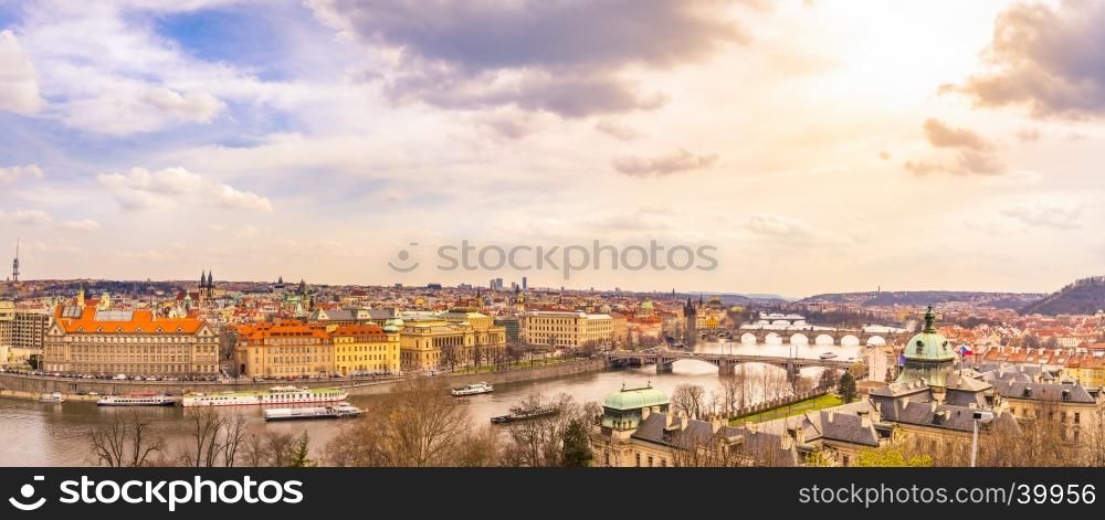 Cityscape panorama of Prague, the capital of Czech Republic, with the Vltava river, the bridges, and all its buildings, under an afternoon sky.