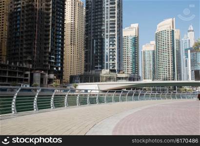 cityscape, travel, tourism and urban concept - Dubai city business district with skyscrapers on seafront and bridge