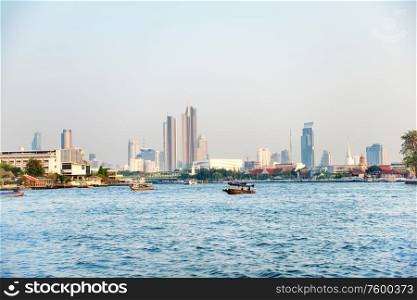 Cityscape view of Bangkok city with Chao Phraya river and skyscrapers in downtown district at skyline. Thailand