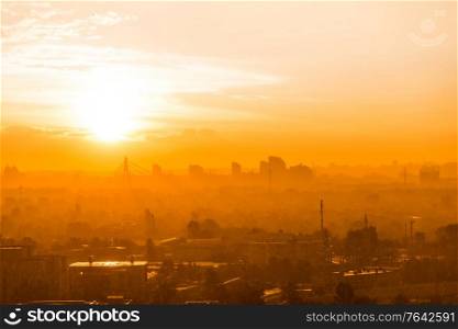 Cityscape with sunset in big city, moderm bridge and buildings under dramatic sunset sky