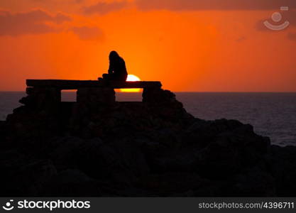 Ciutadella Menorca at Punta Nati orange sunset with girl backlight