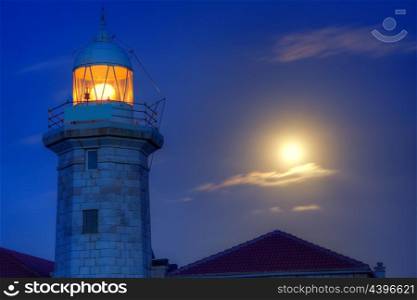 Ciutadella Menorca Punta Nati lighthouse with moon shining in sky