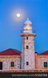 Ciutadella Menorca Punta Nati lighthouse with moon shining in sky