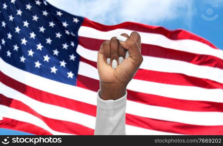 civil rights, equality and patriotism concept - hand of american woman showing fists over american flag on background. hand of african woman over american flag