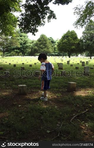Civil War&acute;s Stones River National Battlefield Cemetery, established in 1865, with more than 6,000 Union graves. Murfreesboro Tennesee. Small boy walking through graveyard.