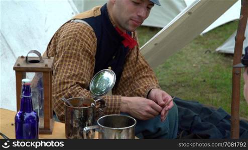 Civil War soldier preps his tobacco pipe