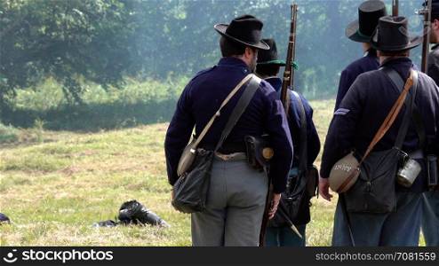 Civil War soldiers shooting across battlefield