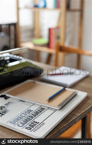 Clapper board and vintage typewriter at wooden desk table. Writer or screenwriter creative concept