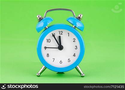 Classic alarm clock on a green background