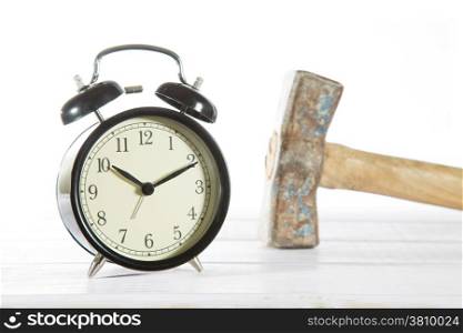 Classic alarm clock with a hammer with white background