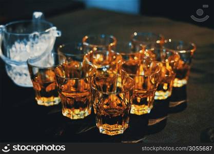 Classic alcohol beverage. Whiskey on old-fashioned glasses on dark background